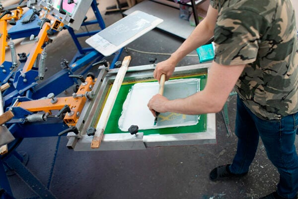 Operatore utilizza una giostra serigrafica